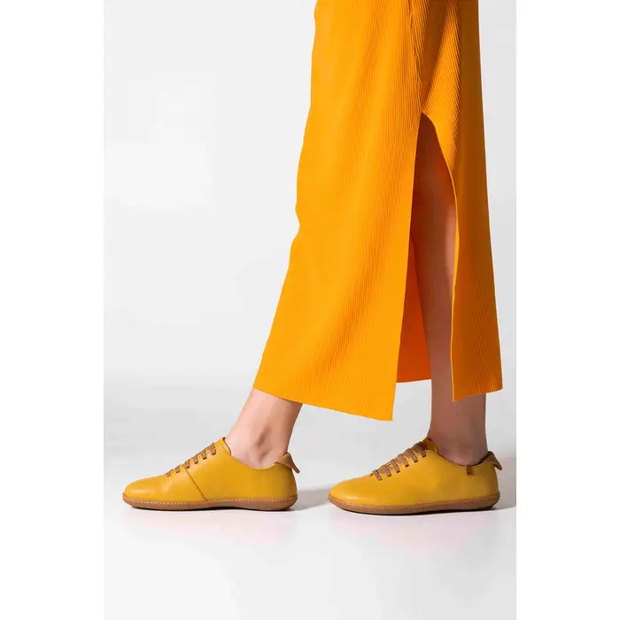 El Naturalista vibrant yellow shoe, crafted with eco-friendly materials and featuring repairable soles, combines style with sustainability for the eco-conscious consumer.