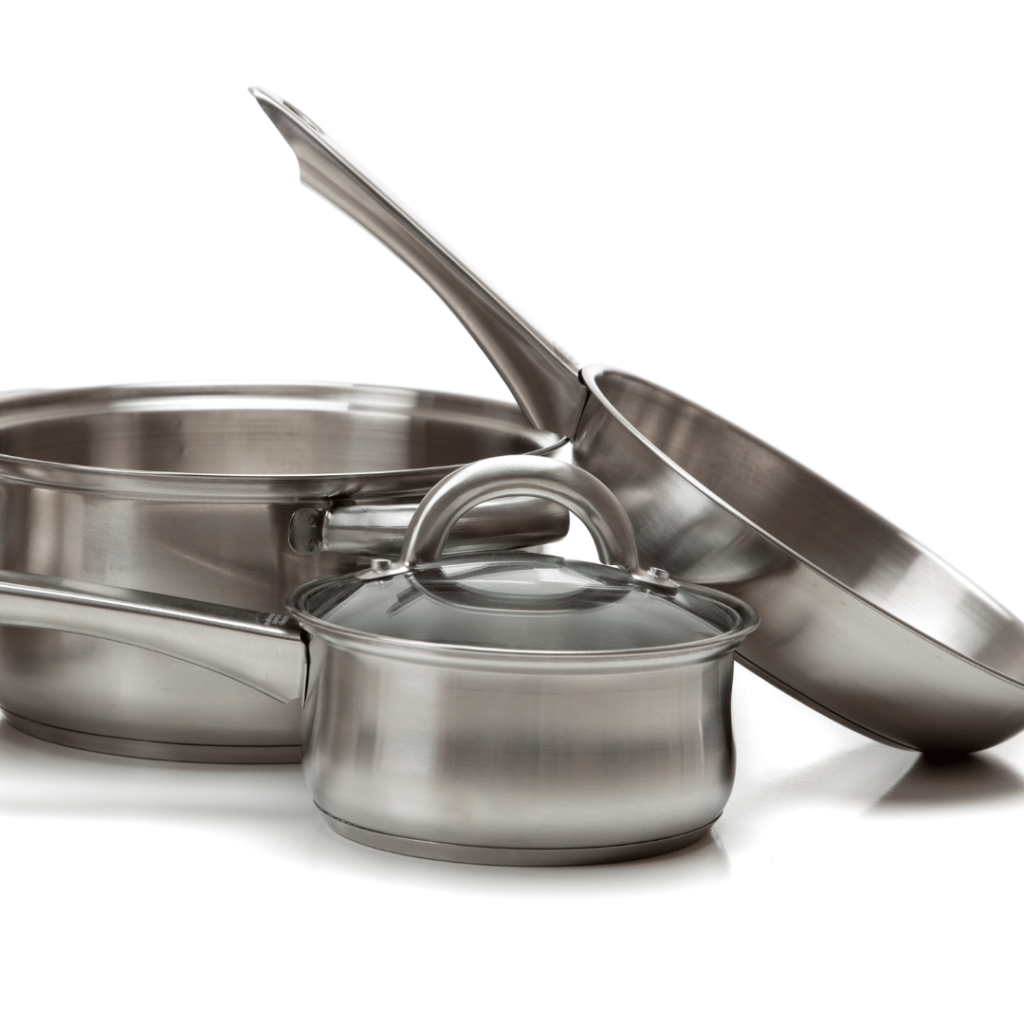 A set of high-quality stainless steel cookware on a white background, including a sauté pan, a saucepan with a glass lid, and a smaller pot. Their robust construction and shiny finish illustrate the durability and long-lasting quality of stainless steel kitchenware.