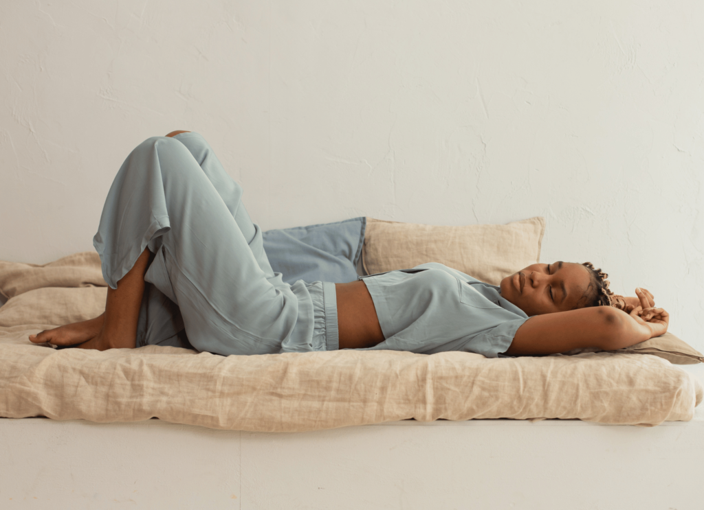 Girl wearing Yala Bamboo clothing lying on a linen bedspread. 